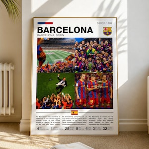 May include: A framed poster featuring the word "BARCELONA" in large, bold letters, with "BARCELONA, SPAIN" beneath. The poster includes images of a soccer team, a stadium, and text detailing the team's history and achievements. The team's logo is also displayed.