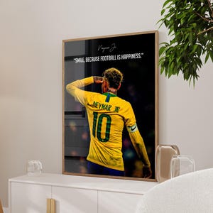 K&ouml;nnte beinhalten: Ein gerahmtes Wandposter mit der R&uuml;ckansicht eines Fu&szlig;ballspielers in einem gelben Trikot mit der Nummer 10 und dem Namen NEYMAR JR. Der Text dar&uuml;ber lautet "SMILE, BECAUSE FOOTBALL IS HAPPINESS." und enth&auml;lt eine Signatur.