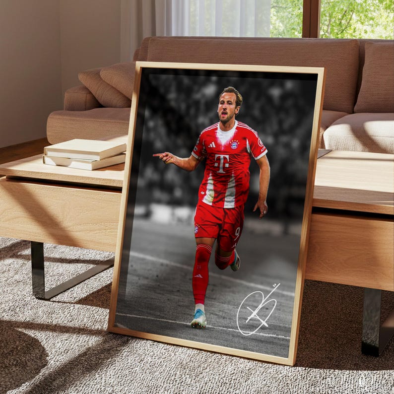 May include: A framed vertical poster featuring a color photograph of a soccer player in a red and white jersey with the letter T on the chest, running on a field. The background is black and white, and a white signature is visible in the corner.