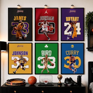 May include: Six framed basketball posters featuring LeBron James, Michael Jordan, Kobe Bryant, Magic Johnson, Larry Bird, and Stephen Curry in action. Each print displays the player's name, jersey number, and team colors with a textured background.