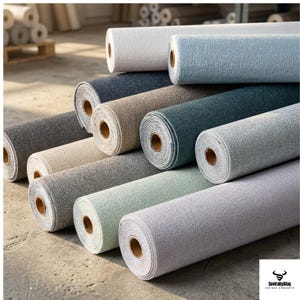 May include: A collection of rolled wallpaper in various colors, including gray, blue, and beige. The rolls are stacked, showcasing the textured surface of the wallpaper. The image highlights the variety of colors and textures available.