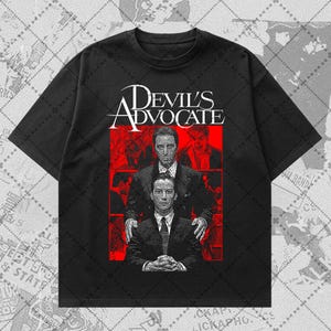 May include: Black t-shirt featuring a graphic from the movie "Devil's Advocate." The design includes the film's title in white, with a red background showcasing two men in suits. The t-shirt is made of a soft, comfortable material.