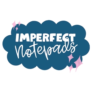 May include: A graphic design featuring the words "IMPERFECT Notepads" in white lettering on a dark teal cloud-shaped background. Pink starbursts accent the design, set against a white backdrop.