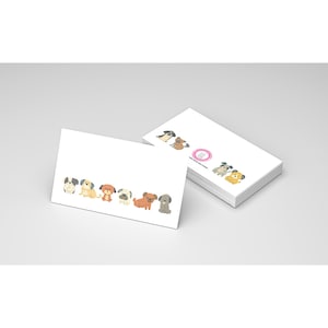 May include: White business cards with a row of cartoon dogs in various colors. The dogs are in different poses and breeds. A stack of cards is visible in the background, with a pink circle and dog illustrations.