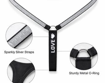 May include: A black harness with sparkly silver straps and a sturdy metal O-ring. The harness features a soft cotton lining and a vertical strap with the word "LOVE" printed on it.