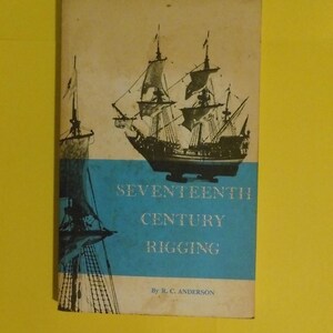 Puede incluir: Un libro antiguo titulado "Seventeenth Century Rigging" con una cubierta azul y blanca. La cubierta presenta ilustraciones de veleros. El libro está sobre un fondo amarillo.