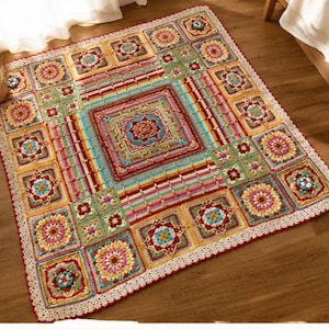 May include: A colorful, square crochet blanket with a floral and geometric pattern. The blanket features a central square design surrounded by smaller squares with floral motifs. The edges are finished with a white lace trim and a red border.