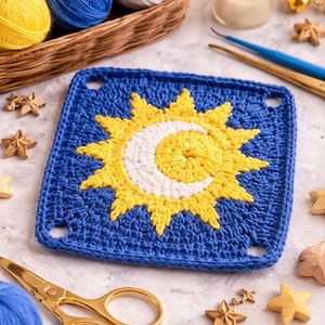 May include: A square, blue crochet piece featuring a yellow sun and a white crescent moon design. The crochet work is surrounded by gold scissors, wooden stars, and balls of yellow, blue, and white yarn. A candle and crochet hooks are also visible.