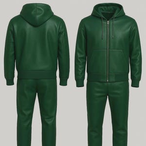 Pode incluir: Um fato de treino de couro verde de duas pe&ccedil;as. O casaco tem capuz, fecho de correr frontal e bolso canguru. As cal&ccedil;as s&atilde;o de perna reta. O fato de treino &eacute; exibido pela frente e por tr&aacute;s.