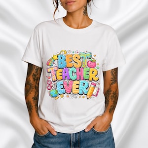 Op de afbeelding: Wit T-shirt met een kleurrijke opdruk van "BEST TEACHER EVER". Het ontwerp bevat een regenboog, appel, potlood, schaar en andere schoolse elementen. Een casual kledingstuk voor dagelijks gebruik.