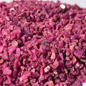 Peut inclure: Gros plan sur un tas de pierres précieuses de rubis brutes et non taillées. Les rubis sont d'une couleur rose-rouge profond et vibrante, avec une texture rugueuse et irrégulière. Les pierres précieuses varient en taille et en forme.
