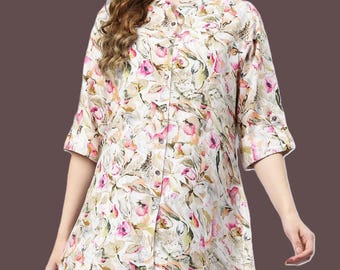 May include: A cream-coloured shirt with a floral pattern, featuring a mandarin collar and three-quarter sleeves. The shirt has a button-down front and a slightly flared hem. The floral design incorporates pink, green, and beige elements.