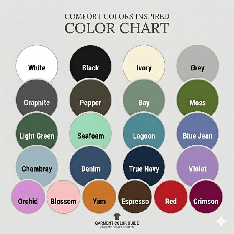 May include: A Comfort Colors inspired color chart featuring twenty-four circular color swatches arranged in a grid. Each circle is labeled with its corresponding color name, including White, Black, Ivory, Grey, Graphite, Pepper, Bay, Moss, Light Green, Seafoam, Lagoon, Blue Jean, Chambray, Denim, True Navy, Violet, Orchid, Blossom, Yam, Espresso, Red, and Crimson.