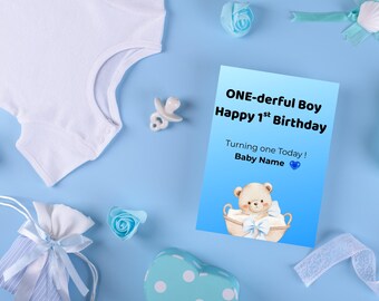 May include: A baby's first birthday card with a teddy bear illustration, surrounded by baby items on a blue background. The card reads "ONE-derful Boy Happy 1st Birthday" and includes space for a baby's name.