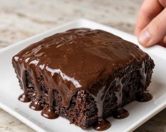 Puede incluir: Un pastel de chocolate de forma cuadrada servido en un plato cuadrado blanco. El pastel tiene una miga densa de color marrón oscuro y está cubierto con una capa espesa y brillante de gancho de chocolate que gotea por los lados.