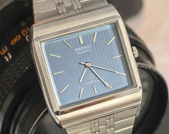 Reloj Seiko Emblem Quartz 4120-5020 con esfera azul y caja cuadrada para hombre.