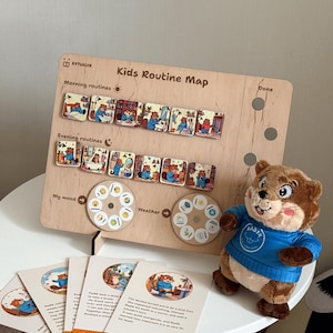 May include: A wooden "Kids Routine Map" with illustrations of a bear, morning and evening routines, and mood and weather indicators. Includes a plush bear toy wearing a blue shirt and cards with text "What Radik Did".