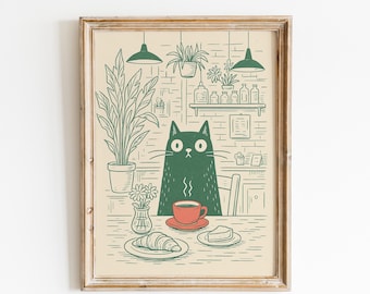 May include: A framed art print featuring a green cat sitting at a table with a cup of coffee, croissant, and cake. The background shows a brick wall, plants, and hanging lights. The artwork is in a minimalist style with green and beige tones.