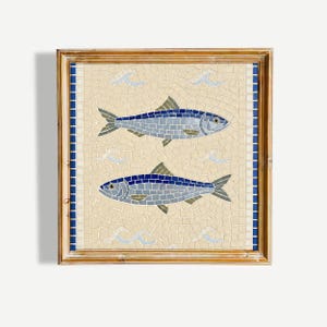 Può includere: Un'opera d'arte murale a mosaico quadrato in una cornice di legno chiaro raffigurante due pesci realizzati con tessere blu e grigie su sfondo crema. Il design include piccoli motivi a onde blu e un bordo verticale di tessere blu sui lati.