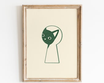 May include: A framed art print featuring a green cat peering through a keyhole. The cat's head is a solid green shape with white eyes and a nose. The keyhole is outlined in green on a cream-colored background, set within a wooden frame.