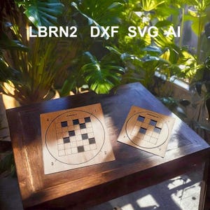 Puede incluir: Dos rompecabezas de madera con un diseño circular y una cuadrícula de cuadrados negros y azules. Los rompecabezas están sobre una superficie de madera oscura. El texto "LBRN2 DXF SVG AI" está en la parte superior de la imagen.