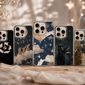 May include: Five clear smartphone cases arranged in a row, each featuring distinct illustrations of rabbits, celestial bodies, stars, and clouds in shades of navy blue, black, gold, and white, with visible camera lens cutouts on the upper left side.