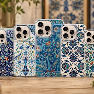 May include: Five smartphone cases arranged in a row, each featuring a distinct blue, white, and red floral or botanical pattern inspired by traditional tile art. The cases are clear with visible camera cutouts and intricate, colourful designs.