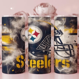 May include: Three cylindrical tumblers with a Pittsburgh Steelers theme. The design features the team logo, a football helmet, and the word "Steelers" in yellow on a dark background with a smoky effect. The tumblers are approximately 8 inches tall.