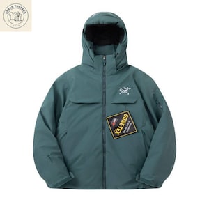 Può includere: Giacca con cappuccio color verde acqua con fodera interna nera. Presenta una cerniera frontale, un piccolo logo bianco sul petto e una toppa GORE-TEX. Design aerodinamico e colletto alto.