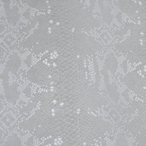 May include: A close-up of a gray fabric with a white, intricate pattern resembling a snake skin texture.