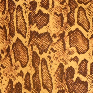 May include: A close-up of a snakeskin pattern. The design features a repeating pattern of brown and dark brown shapes on a yellow-brown background. The texture appears smooth and the pattern is consistent across the surface.