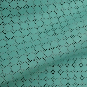 May include: Close-up of a teal leather material featuring a geometric pattern of circles and small perforations. The texture is visible, showing the material's surface and the detailed design.