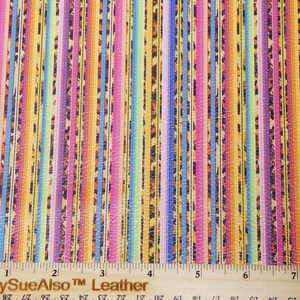 May include: Colorful leather material with vertical stripes in shades of blue, pink, yellow, and orange, with a leopard print pattern. The material is measured with a ruler in inches, and the text "PeggySueAlso Leather" is visible.