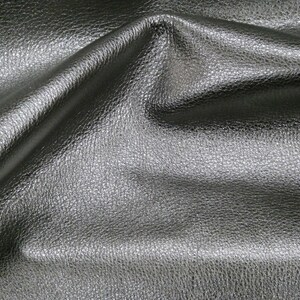 May include: Close-up of a black leather fabric with a textured surface.