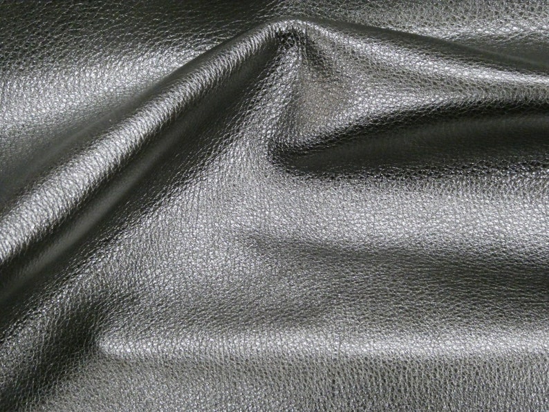 May include: Close-up of a black leather fabric with a textured surface.