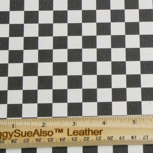 Könnte beinhalten: Schwarzes und weißes Leder mit Schachbrettmuster. Das Muster besteht aus gleichmäßig verteilten Quadraten. Am unteren Bildrand befindet sich ein Holzlineal mit Zollmaßen. Der Text "PeggySueAlso Leather" ist auf dem Lineal aufgedruckt.
