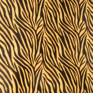 May include: A close-up of a fabric with a black and brown zebra print pattern. The fabric has a textured surface.