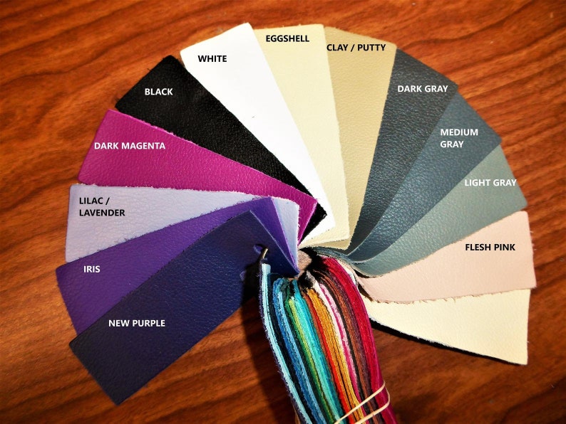 May include: A color chart of leather swatches in various shades of purple, gray, and beige. The swatches are arranged in a circle with the names of each color printed on the top of each swatch.