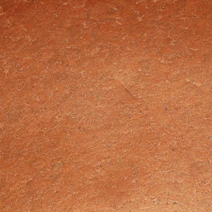 May include: A close-up of a textured, reddish-brown surface. The surface has a slightly rough, uneven texture, similar to cork.