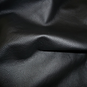May include: Close-up of black leather with a pebbled texture.