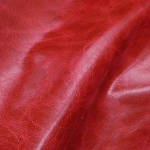 May include: Close-up of a deep red leather texture with a wrinkled, distressed look.
