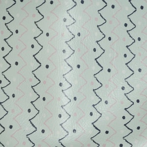May include: A light green fabric with a repeating pattern of black zigzags, black dots, and pink dots.
