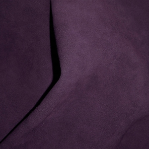 Könnte beinhalten: Nahaufnahme eines tiefvioletten Stoffes mit glatter Textur. Der Stoff ist in der Mitte gefaltet, wodurch eine Falte entsteht.