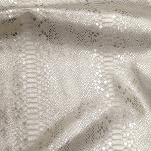 May include: Close-up of a shimmering fabric with a snakeskin pattern. The material is a light, neutral colour with a subtle sheen, creating a luxurious appearance. The pattern is detailed and realistic.