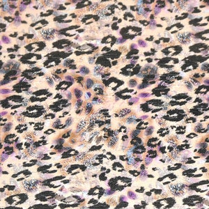 May include: A beige fabric with a black and purple leopard print pattern.