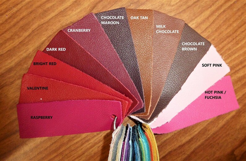 May include: A leather color chart with 12 different shades of red, pink, brown, and tan. The colors are labeled with names like "Raspberry", "Valentine", "Dark Red", "Chocolate Maroon", "Oak Tan", "Milk Chocolate", "Chocolate Brown", "Soft Pink", and "Hot Pink/Fuchsia".