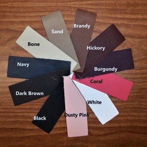 May include: A color chart of leather swatches in various shades, including Brandy, Hickory, Burgundy, Coral, White, Dusty Pink, Black, Dark Brown, Navy, Bone, and Sand.