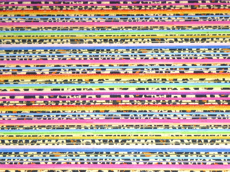 May include: A close-up of a colorful striped fabric with a repeating pattern of black and white animal print. The fabric is made of a variety of materials, including cotton, silk, and linen.