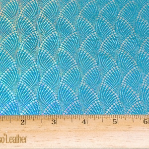 May include: A close-up of turquoise fabric with a white iridescent pattern of overlapping circles. A wooden ruler with the text "PeggySueAlsoLeather" is at the bottom of the image.