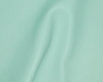 May include: A close-up of a light blue textured fabric. The fabric has a smooth, soft surface and a subtle sheen.